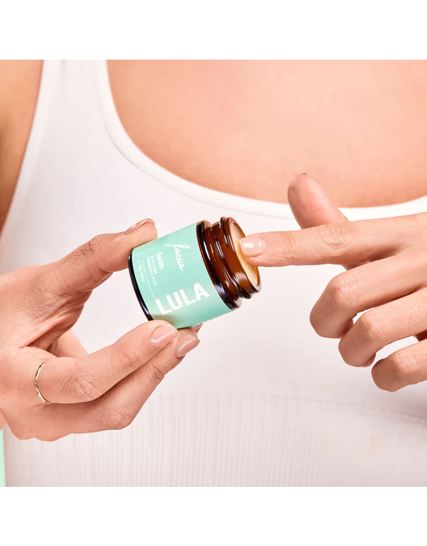Lula Focus Balm, an essential oil product with natural ingredients, displayed in a small jar with a wooden lid.