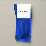 Bright electric blue glitter lurex socks by Klue, showcasing their shiny, textured fabric design in a stylish sock packshot.