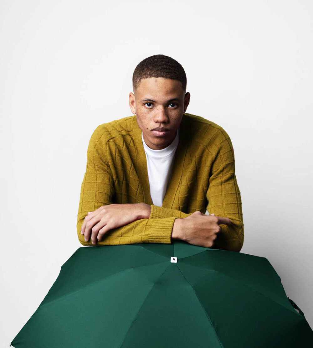 Green Anatole Gustave micro-umbrella open showing compact size and lightweight design, perfect for travel and everyday use.