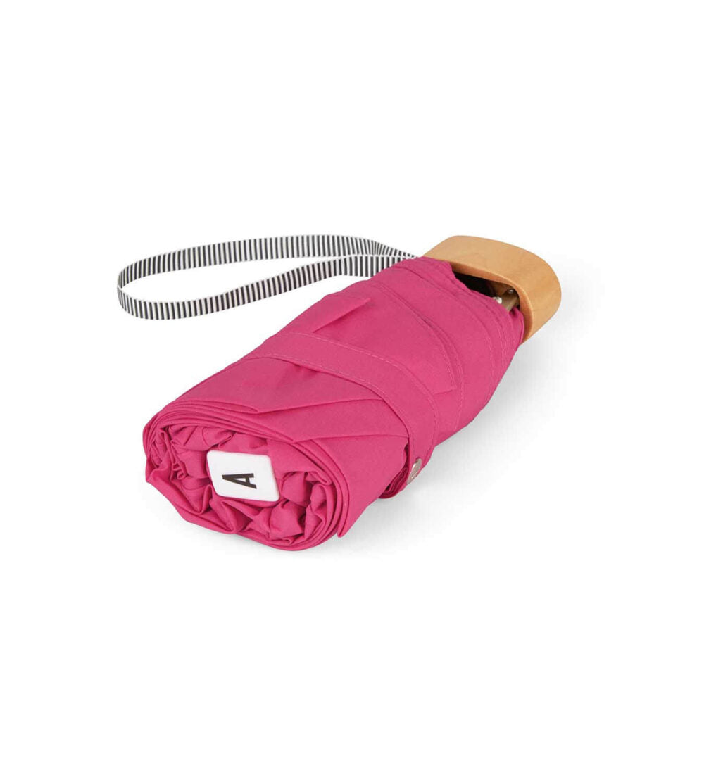 Pink Suzanne micro-umbrella by Anatole with fuchsia canopy and compact pink case, perfect for rain protection and portability.