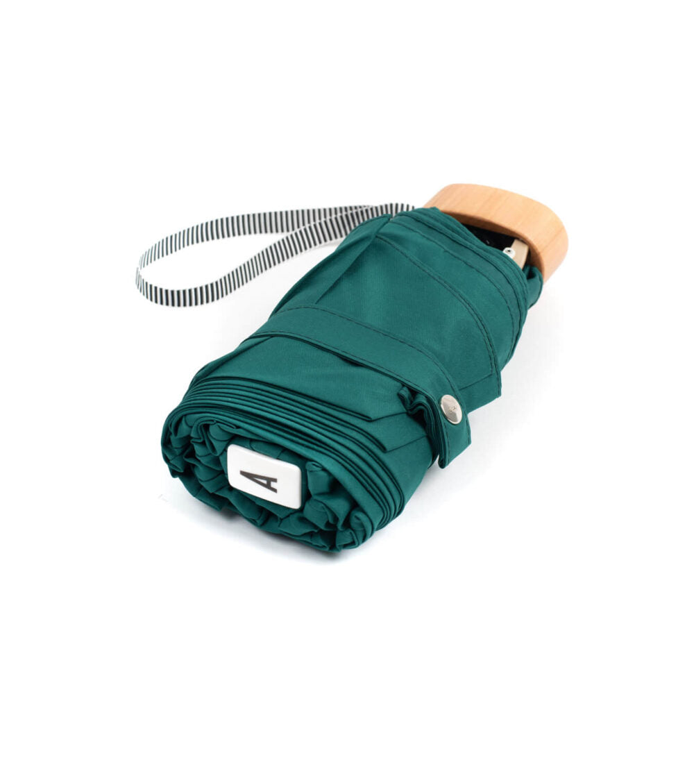 Green Anatole Gustave micro-umbrella featuring a compact design and sturdy handle, ideal for rain protection.