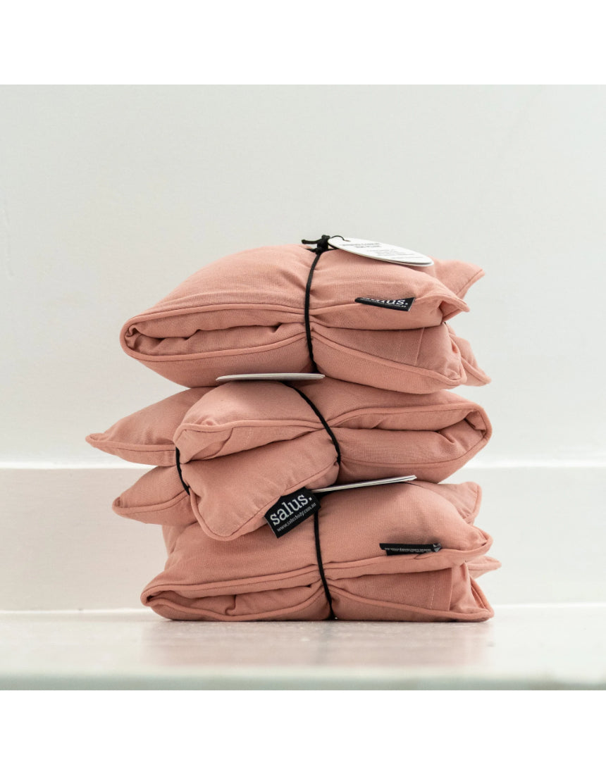 Salus Lavender & Barley heat pillow in blush, square-shaped bath and body product with soft pink fabric and plush texture.
