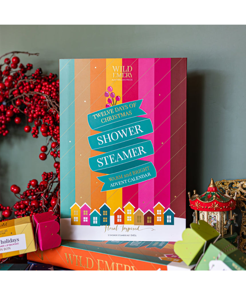 Wild Emery warm and bright Christmas shower steamer advent calendar with 12 festive shower bombs in colorful packaging