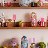 Kip & Co Festiva glass and carafe set with vibrant, colorful patterns on clear glass for serving beverages.