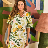 Kip & Co Wander apron featuring colorful floral pattern, tied waist, and adjustable neck strap, ideal for cooking or gardening.