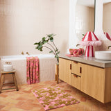 Kip & Co Bloom bath mat with colorful floral pattern, soft textured surface, and non-slip backing for bathroom safety.