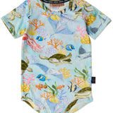 Baby wearing Kip & Co Reef Life short sleeve romper with colorful tropical print, short sleeves, and comfortable fit.