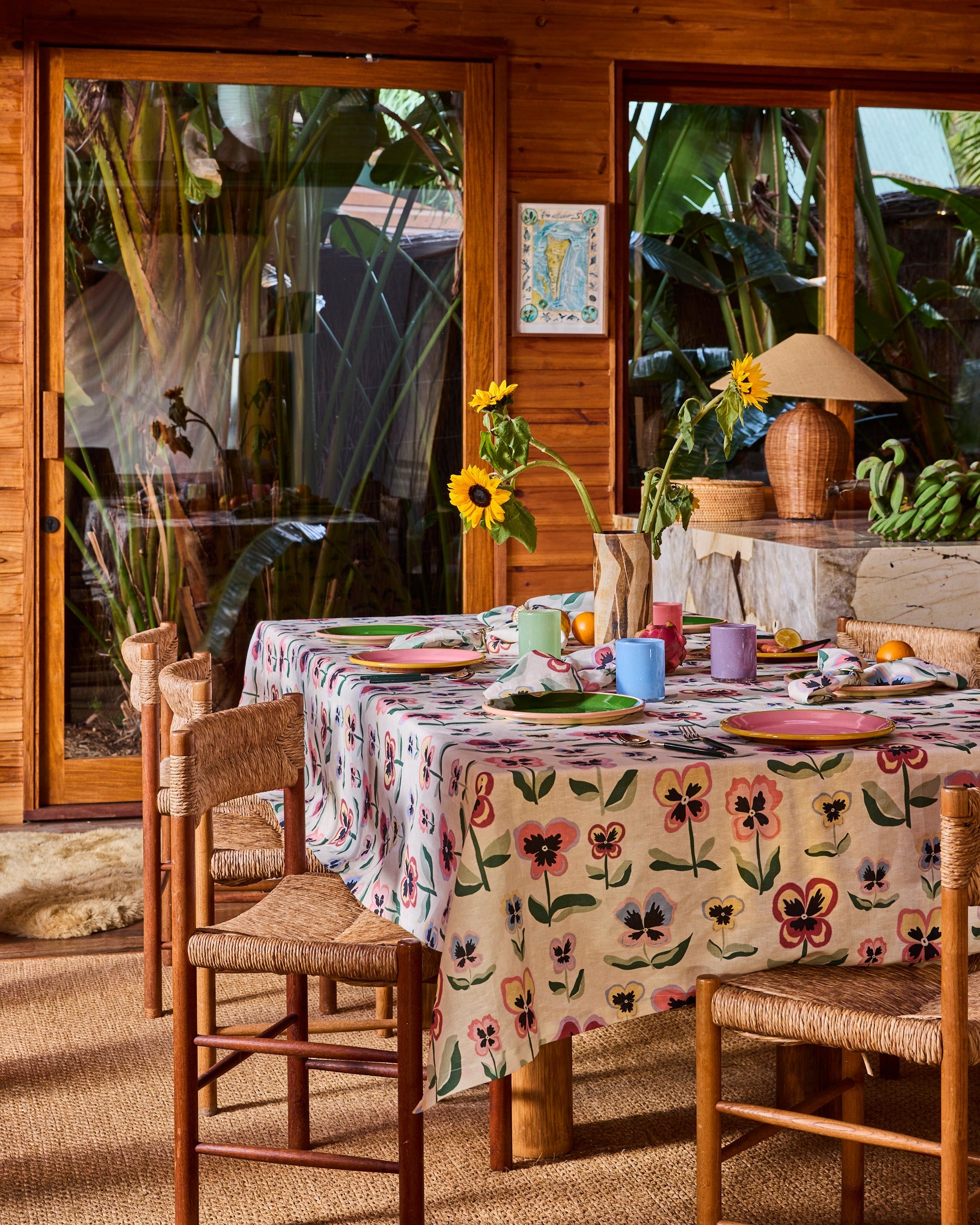 Kip & Co Pretty Pansy tablecloth with colorful floral design, draped over a dining table for a vibrant, stylish look.