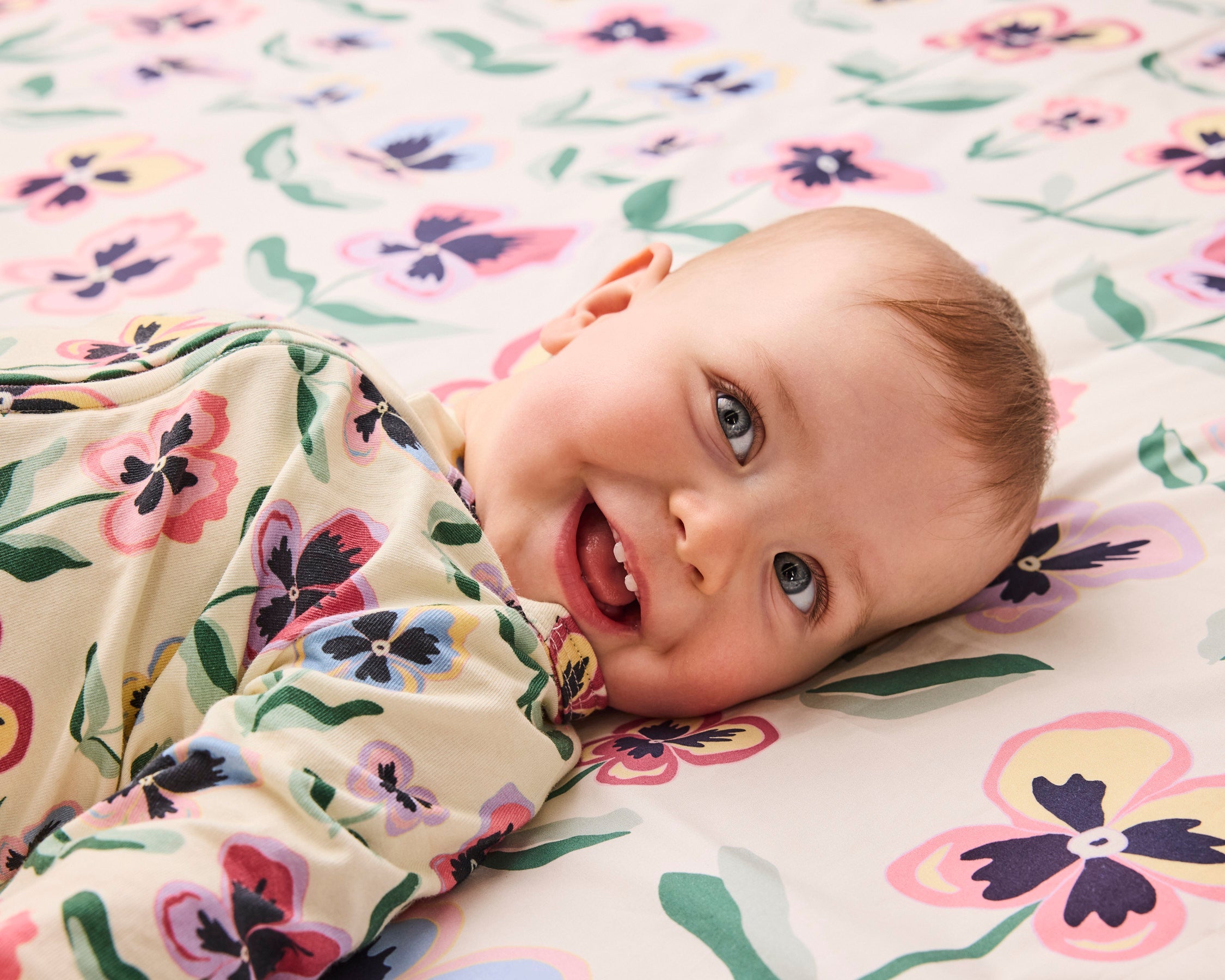 Kip & Co Pretty Pansy organic long sleeve zip romper for babies, featuring floral print and soft cotton fabric.