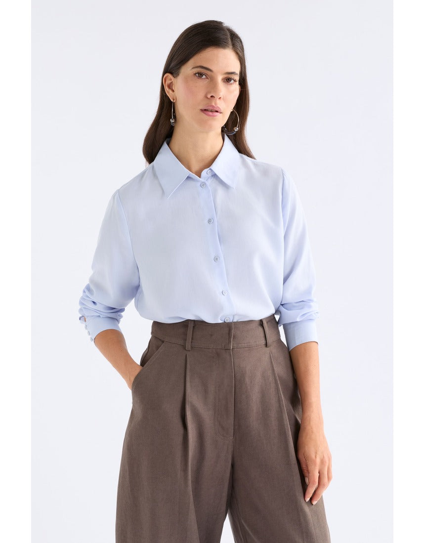 Pale blue Tettu shirt by ELK The Label, a stylish women's top with soft fabric and classic fit, displayed on a hanger.