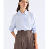 Pale blue Tettu shirt by ELK The Label, a stylish women's top with soft fabric and classic fit, displayed on a hanger.