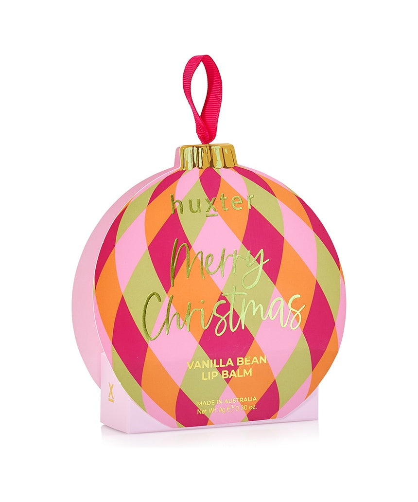 Huxter Adorned Christmas Hanging Lip Balm in soft pink, decorative holiday packaging, hanging with festive decorations.