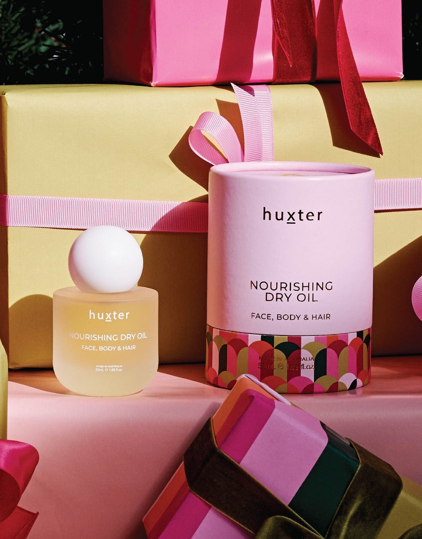 Huxter Christmas Nourishing Dry Oil styled with colourful gifts