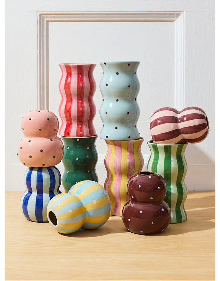 Jones & Co Palma Vase in green with pink dot pattern, showcasing its decorative ceramic design and colorful floral display.