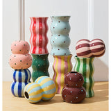 Jones & Co Palma Vase in green with pink dot pattern, showcasing its decorative ceramic design and colorful floral display.