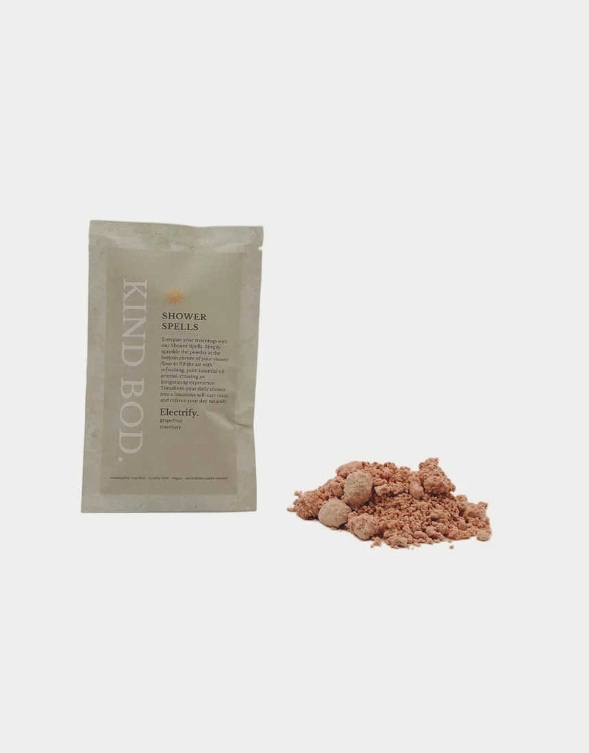 Kind Bod Shower Spells shower bomb with calming Zen scent, shown in a clear container with colorful bath salts and botanical accents.