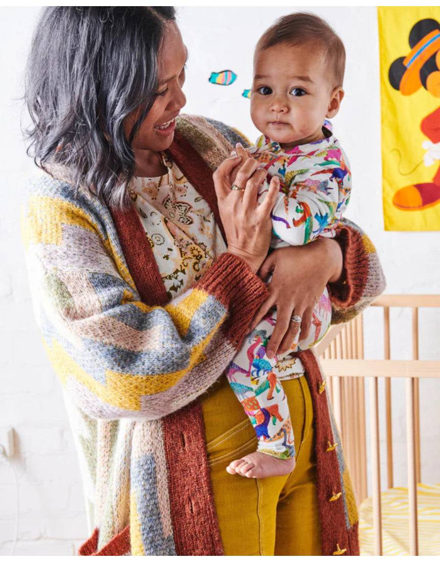Dino Max white organic long sleeve zip romper for babies by Kip & Co, featuring a cute dinosaur print and soft fabric.