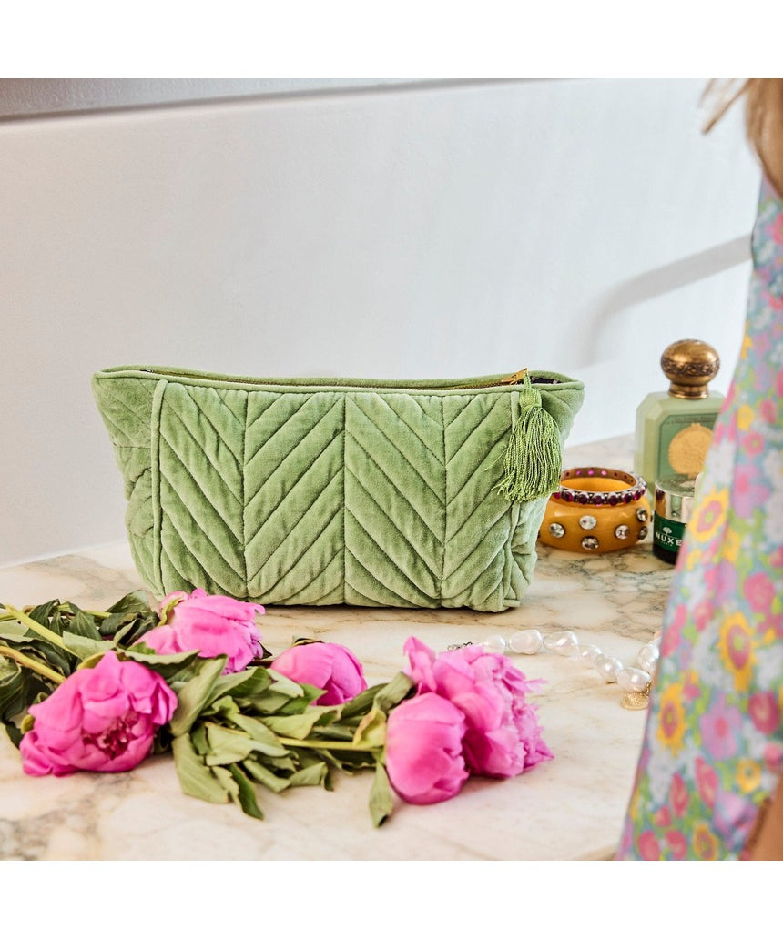 Kip&Co velvet toiletry bag in pesto green with a soft, plush texture, featuring a zip closure and compact design for travel toiletries.