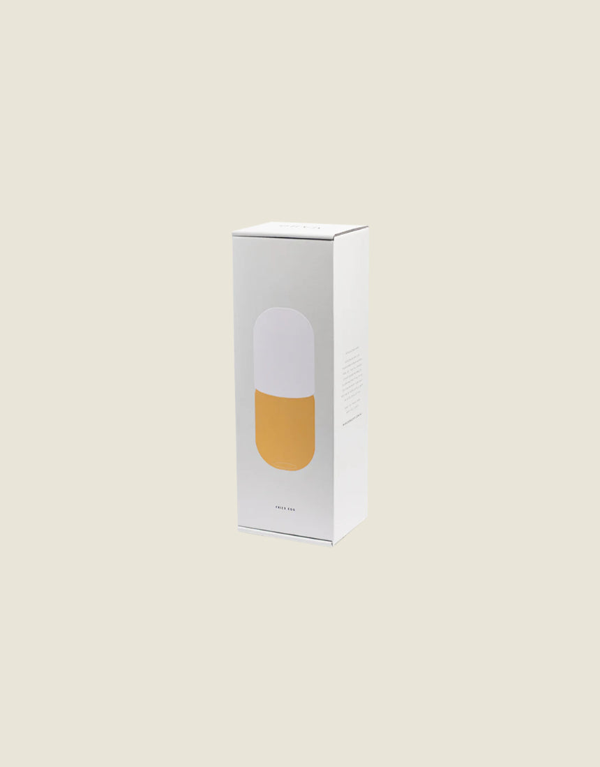 Maho Happi Pill box packaging featuring a fried egg illustration, showcasing the product's playful design and branding.