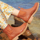 Rust-colored Merry People Bobbi Gumboot shoes with a sleek rubber design and sturdy soles, perfect for rainy weather.