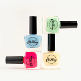 Kids nail polish in cream violet by Oh Flossy, showing a small bottle with colorful label and vibrant violet polish inside.