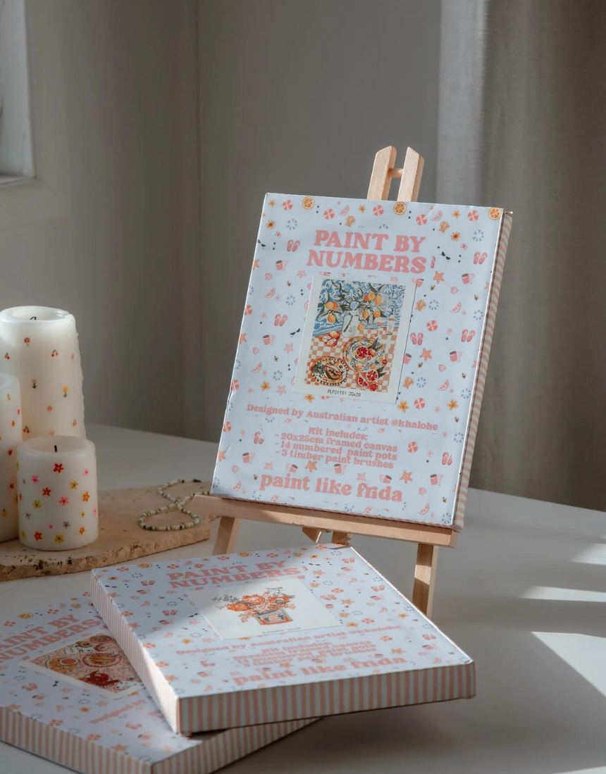 Paint Like Frida paint by numbers kit featuring a mini art easel and a Frida Kahlo-inspired design for creative art projects.