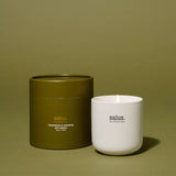 Salus Cedarwood and Geranium soy candle in a glass jar, placed on a wooden table with a cozy, relaxing ambiance.
