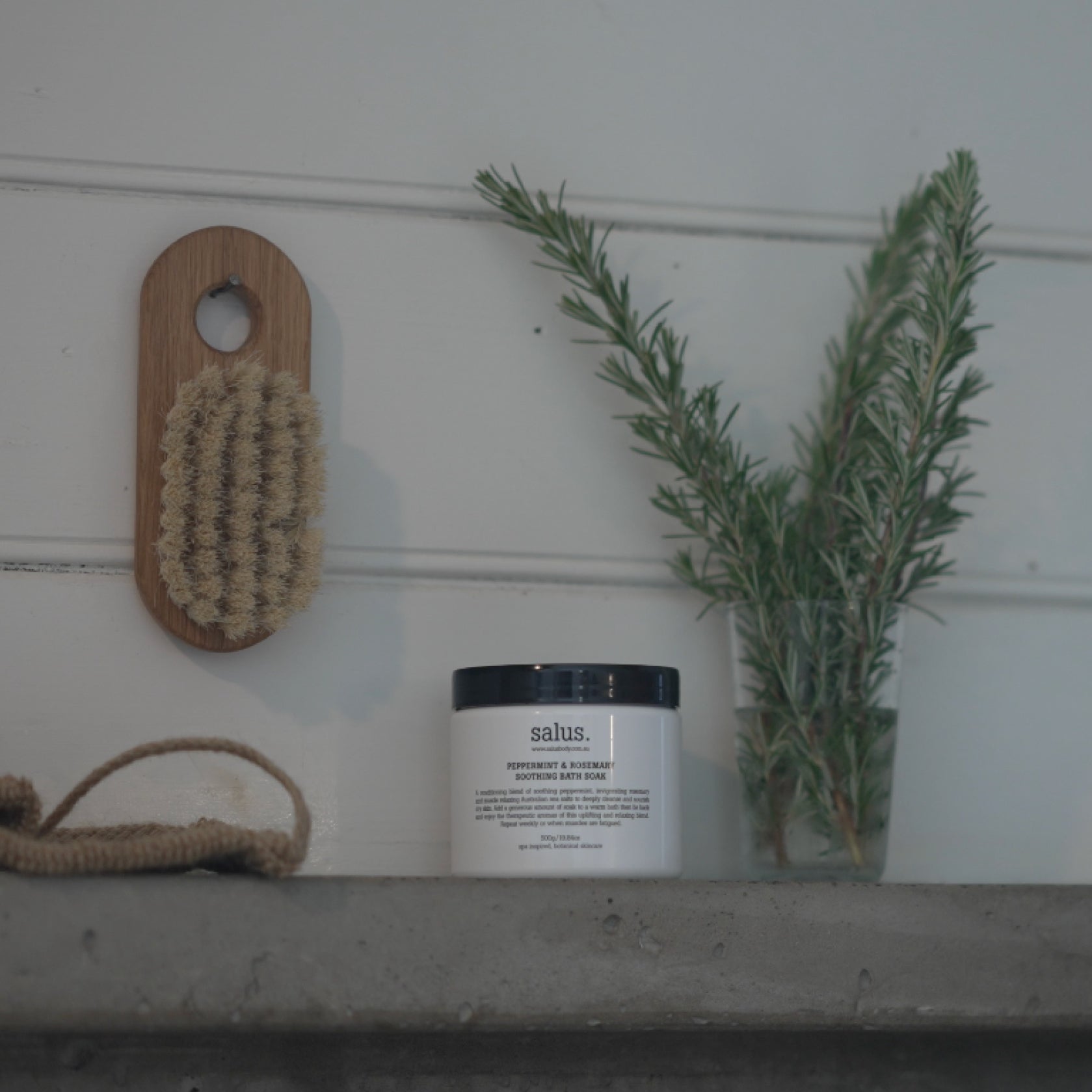Salus Peppermint and Rosemary soothing bath soak in a clear jar with a white lid, showcasing the herbal bath product.