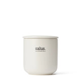 Salus Rose Geranium Soy Candle with 55-65 hour burn, featuring a glass jar and floral label, ideal for relaxing home ambiance.