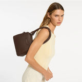 Status Anxiety Mini Mountains Bag in cocoa color, featuring a compact design with adjustable strap and stylish mountain pattern.