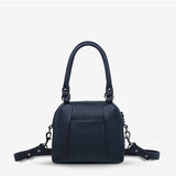 Midnight blue Status Anxiety Mini Mountains bag showing front view with adjustable strap and minimalist mountain design.