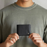 Black Leonard Wallet by Status Anxiety, a sleek leather wallet with multiple card slots and a minimalist design.