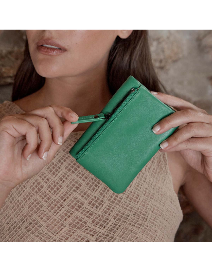 Status Anxiety Is Now Better Wallet in emerald green, featuring multiple card slots and a sleek, compact design.