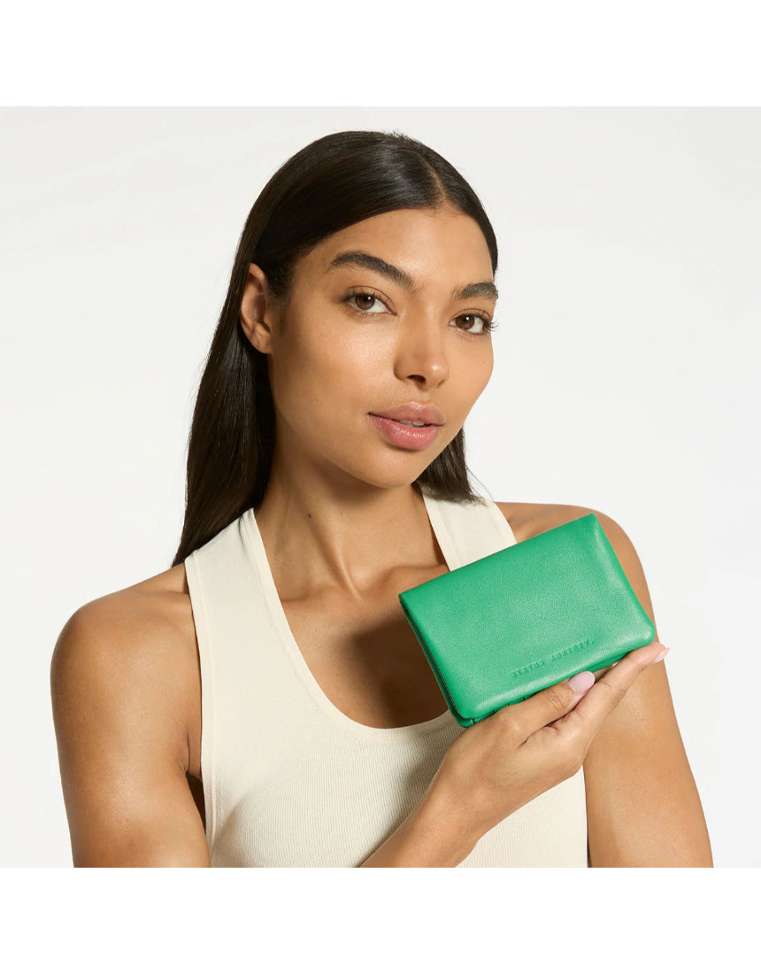 Status Anxiety Is Now Better Wallet in emerald green, showing its compact design and multiple card slots.