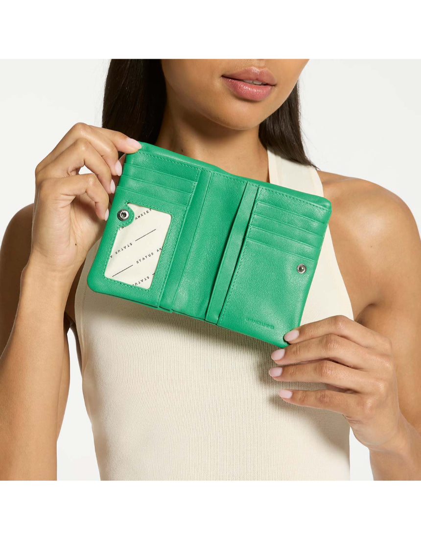 Status Anxiety Is Now Better Wallet in emerald green, showing a sleek leather wallet with multiple card slots and a minimalist design.