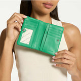 Status Anxiety Is Now Better Wallet in emerald green, showing a sleek leather wallet with multiple card slots and a minimalist design.