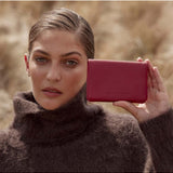 Status Anxiety Is Now Better Wallet in Rouge, featuring a sleek leather design with multiple card slots and a compact silhouette.