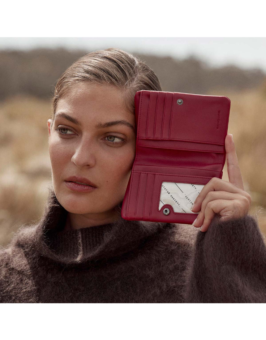 Status Anxiety Is Now Better wallet in rouge, featuring a sleek design and multiple card slots, perfect for everyday use.