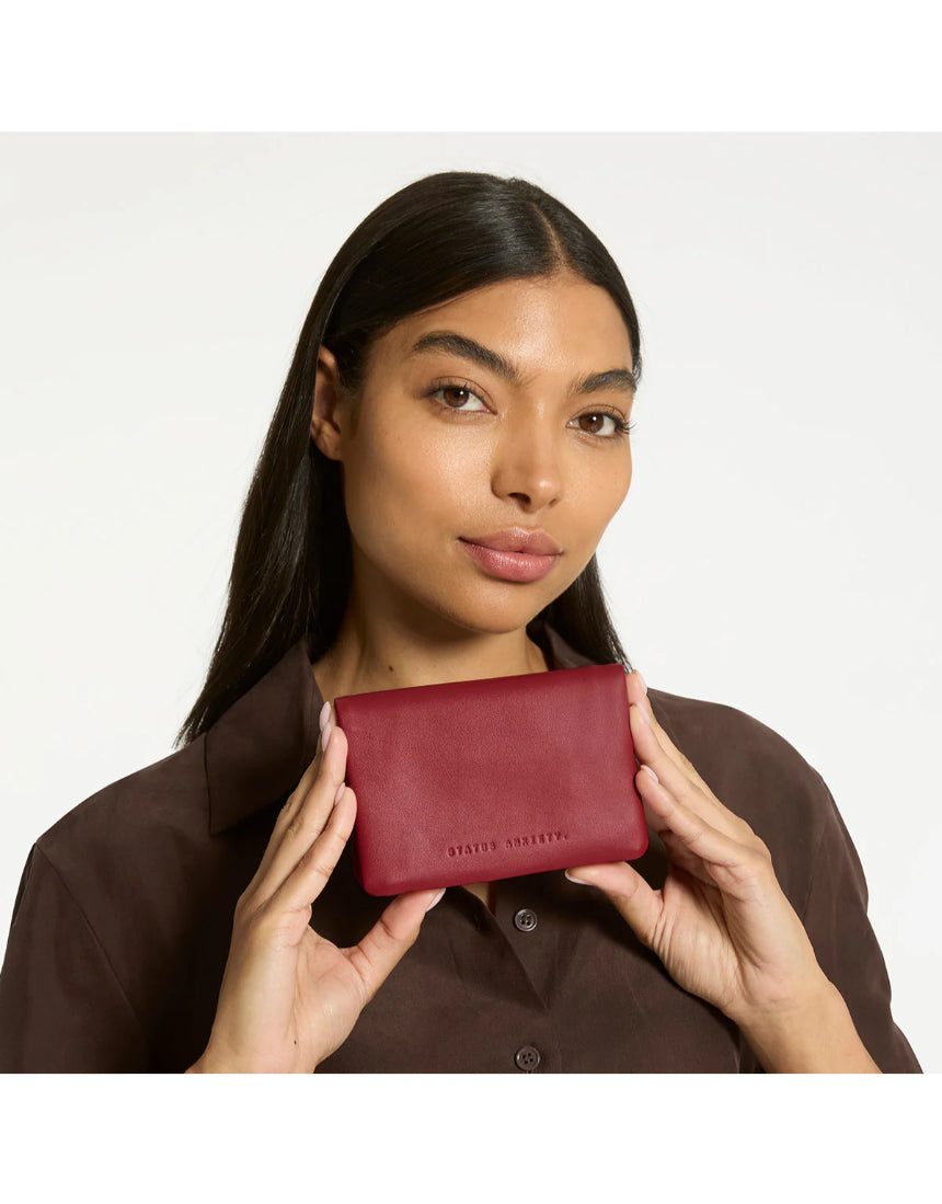 Status Anxiety Is Now Better Wallet in rouge color, featuring a sleek design with multiple card slots and a compact profile.