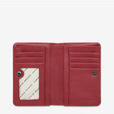 Open Status Anxiety Is Now Better Wallet in rouge, showing smooth leather exterior and organized interior compartments.