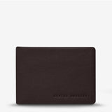 Status Anxiety Jonah Wallet in chocolate color, front view showing sleek leather design and compact wallet features.