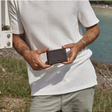 Chocolate Status Anxiety Jonah Wallet with multiple card slots and sleek design, shown in lifestyle setting.