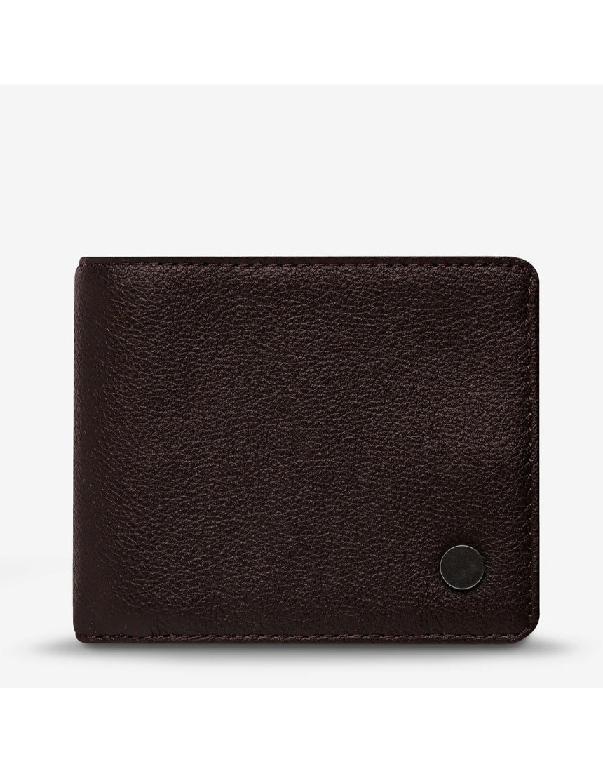 Status Anxiety Leonard Wallet in chocolate brown with a sleek leather design, featuring multiple card slots and a secure fold-over closure.