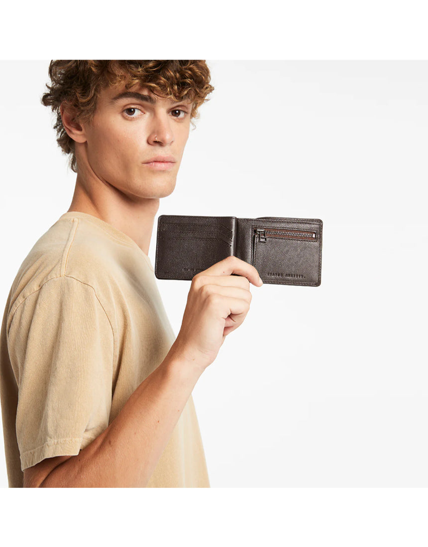 Status Anxiety Leonard Wallet in chocolate brown, featuring a sleek leather design and multiple card slots.