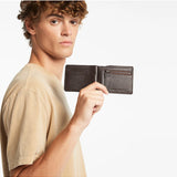 Status Anxiety Leonard Wallet in chocolate brown, featuring a sleek leather design and multiple card slots.