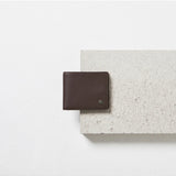 Status Anxiety Leonard Wallet in chocolate leather, featuring multiple card slots and a sleek design.