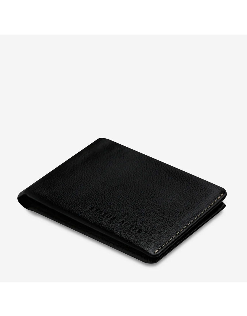 Black Status Anxiety Otis Wallet with sleek leather design, top-angle view showing card slots and compact wallet shape.