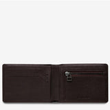 Open Status Anxiety Otis Wallet in chocolate brown, displaying multiple card slots and cash compartment on a flat surface.