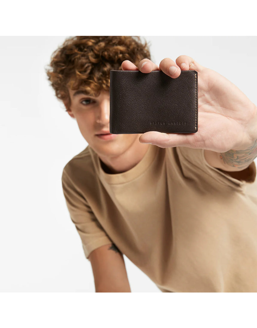 Status Anxiety Otis Wallet in chocolate color, featuring multiple card slots and a sleek leather design.