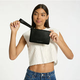 Black Status Anxiety Take Your Chances wallet with multiple card slots and a sleek design, shown in a lifestyle setting.